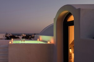 Una terraza en la azotea con piscina, dos copas de vino y velas.