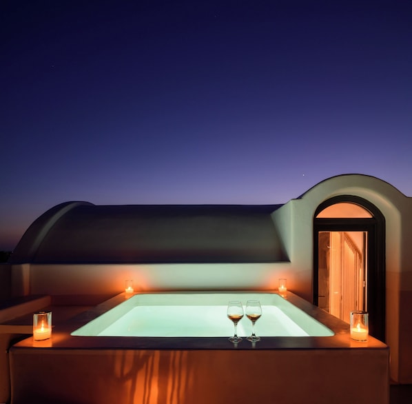 A hot tub with two glasses of wine, a candle, and a view of the sky at dusk. - Penny's House New Luxe Jacuzzi Villa 400m from Sea (Santorini)