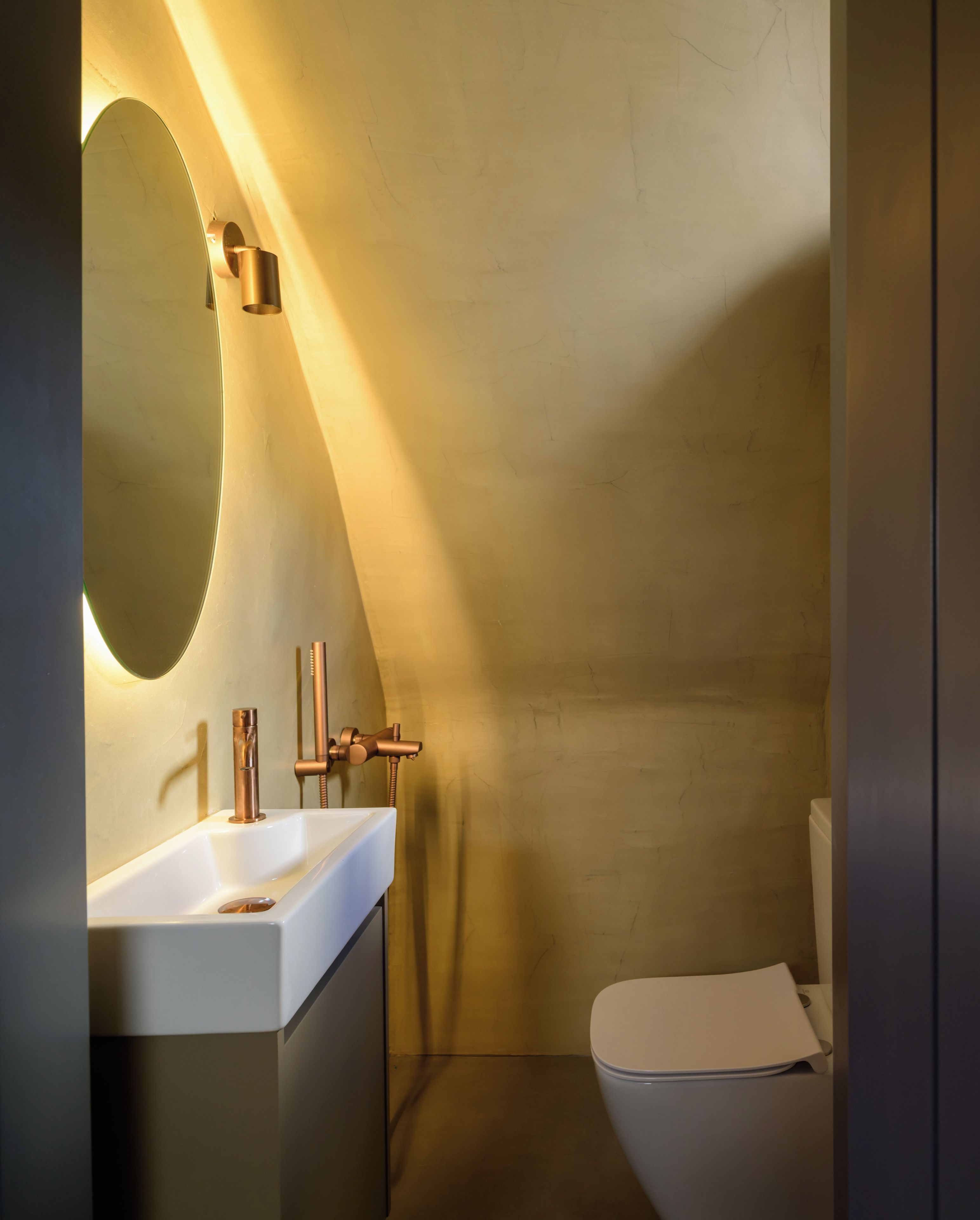 Une salle de bain moderne avec un lavabo blanc, un grand miroir et des toilettes.