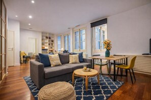Ein Wohnzimmer mit einer Couch, einem Couchtisch und einem Essbereich mit Stühlen.
