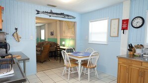 A kitchen with a dining table, chairs, a clock, and a map on the wall. - Budget Friendly Apartment with Ample Boat Parking! (Cedar Key)
