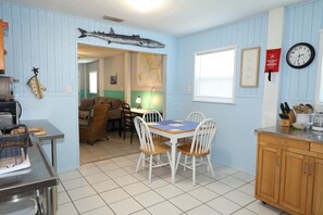 A kitchen with a dining table, chairs, a clock, and a map on the wall. - Budget Friendly Apartment with Ample Boat Parking! (Cedar Key)