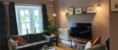 A living room with a sofa, coffee table, and a flat-screen TV.
