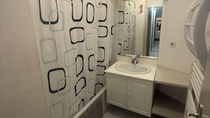 A bathroom with a shower curtain, a sink, and a mirror. - Paradise Riviera St laurent du Var-Nice  (Saint-Laurent-du-Var)