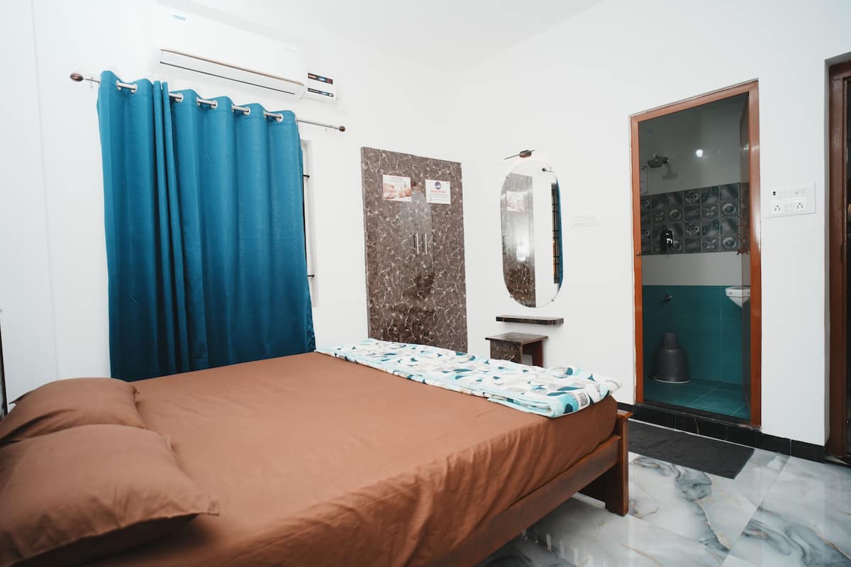Une chambre avec un lit, une salle de bain avec douche et un sol en marbre.