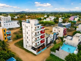 A multi-story residential building with balconies, a swimming pool, and a view of the surrounding area.
