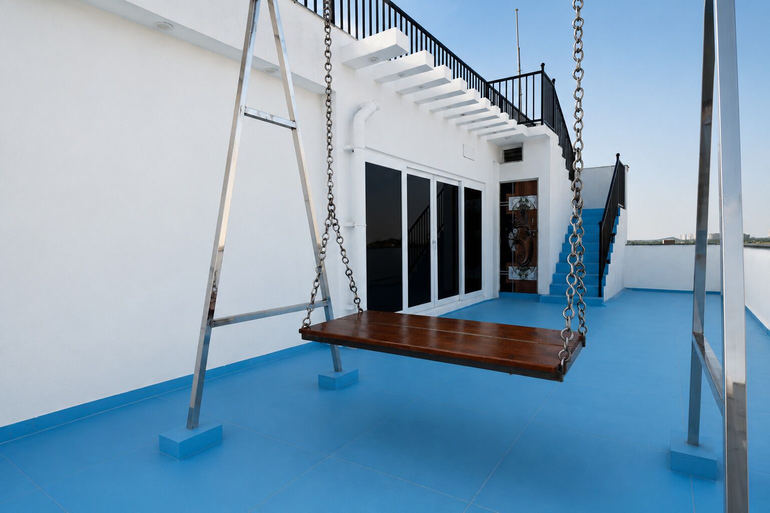 Le pont d’un navire est équipé d’une balançoire, d’un escalier et d’une porte donnant accès à un espace intérieur.