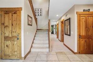 Ein Korridor mit Holztüren, einer Treppe und einem gerahmten Bild an der Wand.