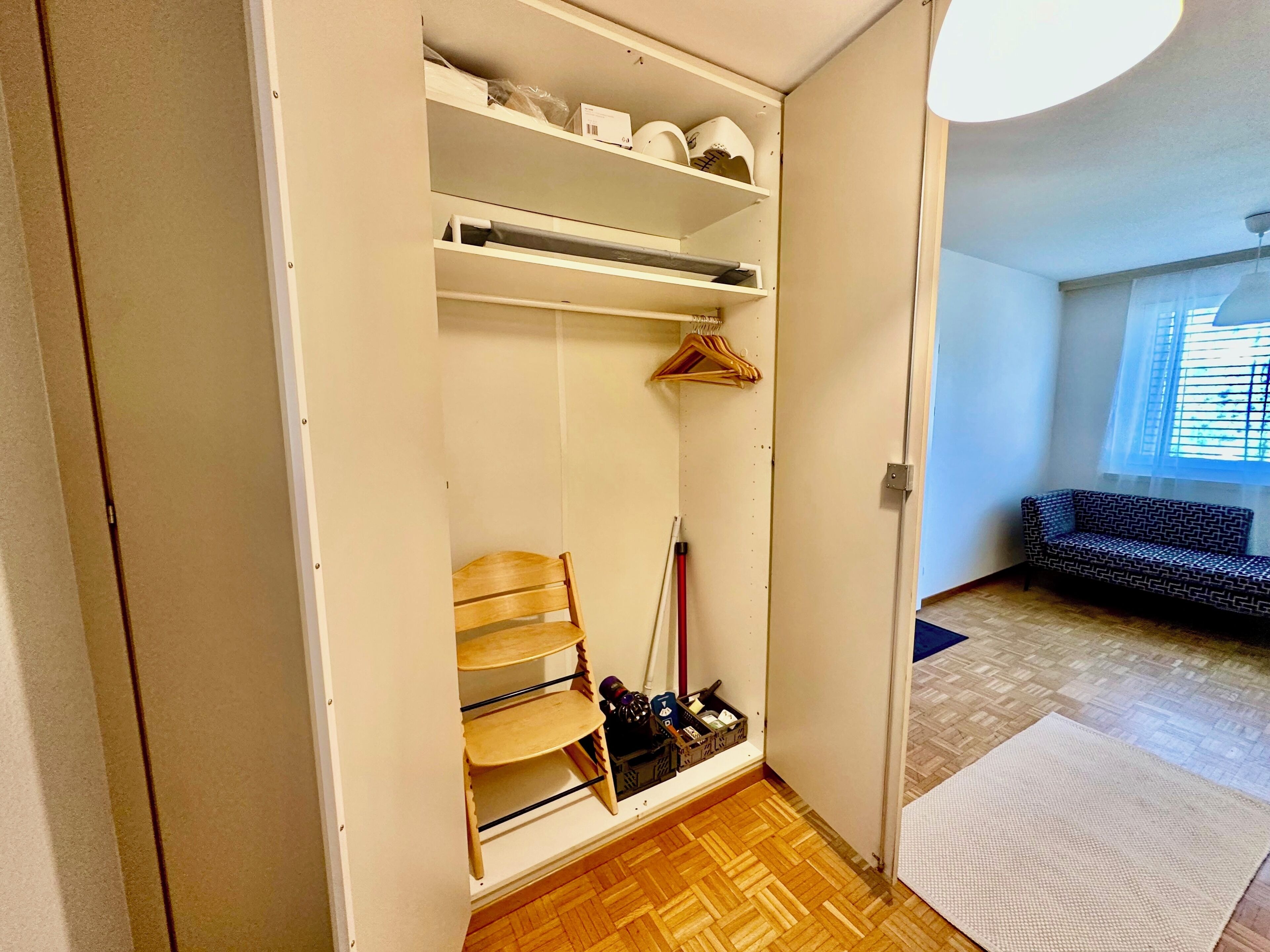 Un dressing avec des étagères, une chaise et un portant à vêtements.