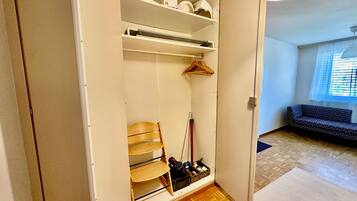 Un dressing avec des étagères, une chaise et un portant à vêtements.