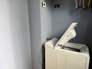A room with a white heater, a wall-mounted thermostat, and a visible electrical outlet. - Purple Nest House (Turin)