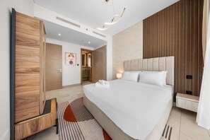 Ein modernes Hotelzimmer mit einem großen Bett, einem Holzschrank und einer kleinen Sitzecke.