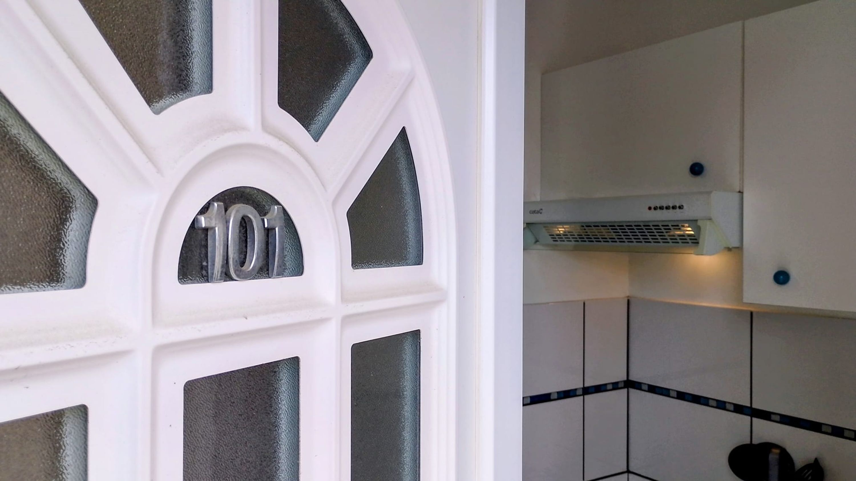 A white door with a geometric pattern and the number '101' in the center.
