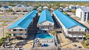 A resort with multiple buildings, a swimming pool, and outdoor seating areas. - Gulf Shores Beach Condo With Pool (Gulf Shores)