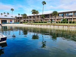 A waterfront hotel with a pool, palm trees, and a beach area. - Waterfront 2-bedroom Condo in Panama City (Panama City)