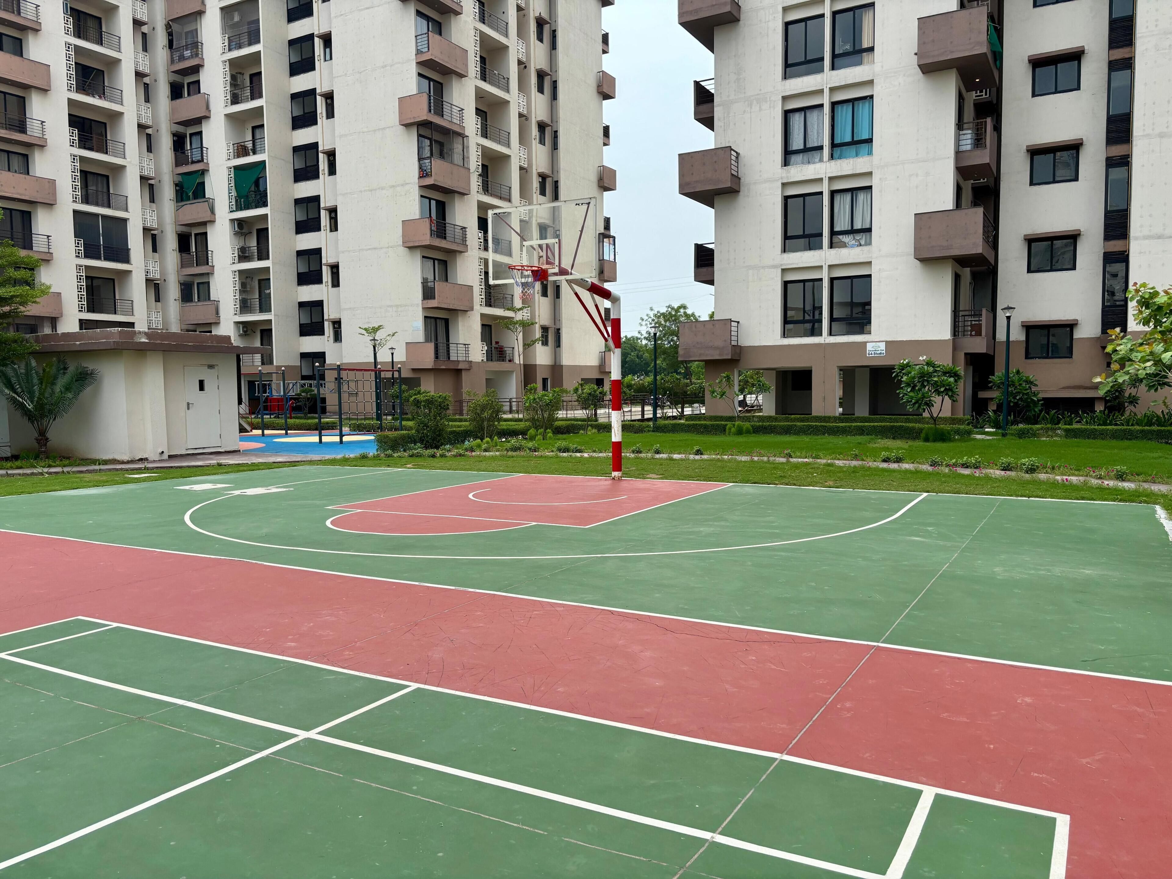 A basketball court surrounded by residential buildings.