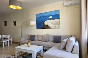 Ein Wohnzimmer mit einer Couch, einem Couchtisch, einem Gemälde und einer Lampe.