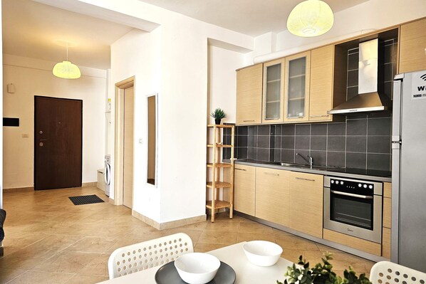 Eine moderne Küche mit Holzausstattung, einem Backofen und einem Kühlschrank.