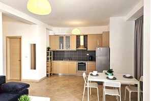 Eine moderne Küche mit Holzschränken, einem eingebauten Ofen und einem Essbereich mit Tisch und Stühlen.