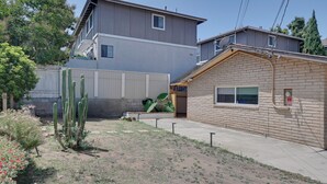A two-story building with a flat roof, a small attached garage, and a garden with cacti and flowers. - 1 Mi to Military Base: Cozy Imperial Beach Studio (Imperial Beach)