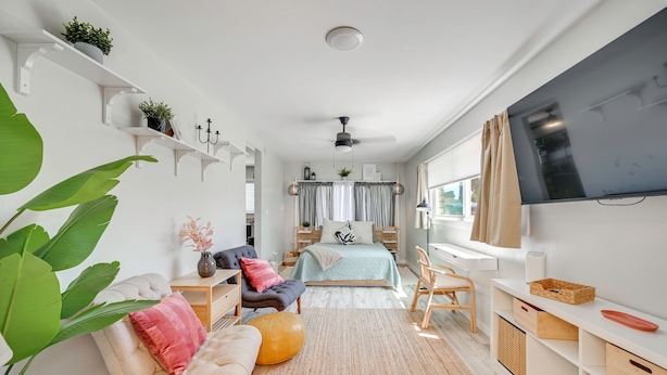 A modern bedroom with a bed, bedside tables, a TV, and a large window. - 1 Mi to Military Base: Cozy Imperial Beach Studio (Imperial Beach)