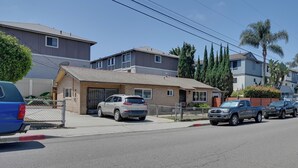 A residential street with houses, parked cars, and a clear sky. - 1 Mi to Military Base: Cozy Imperial Beach Studio (Imperial Beach)