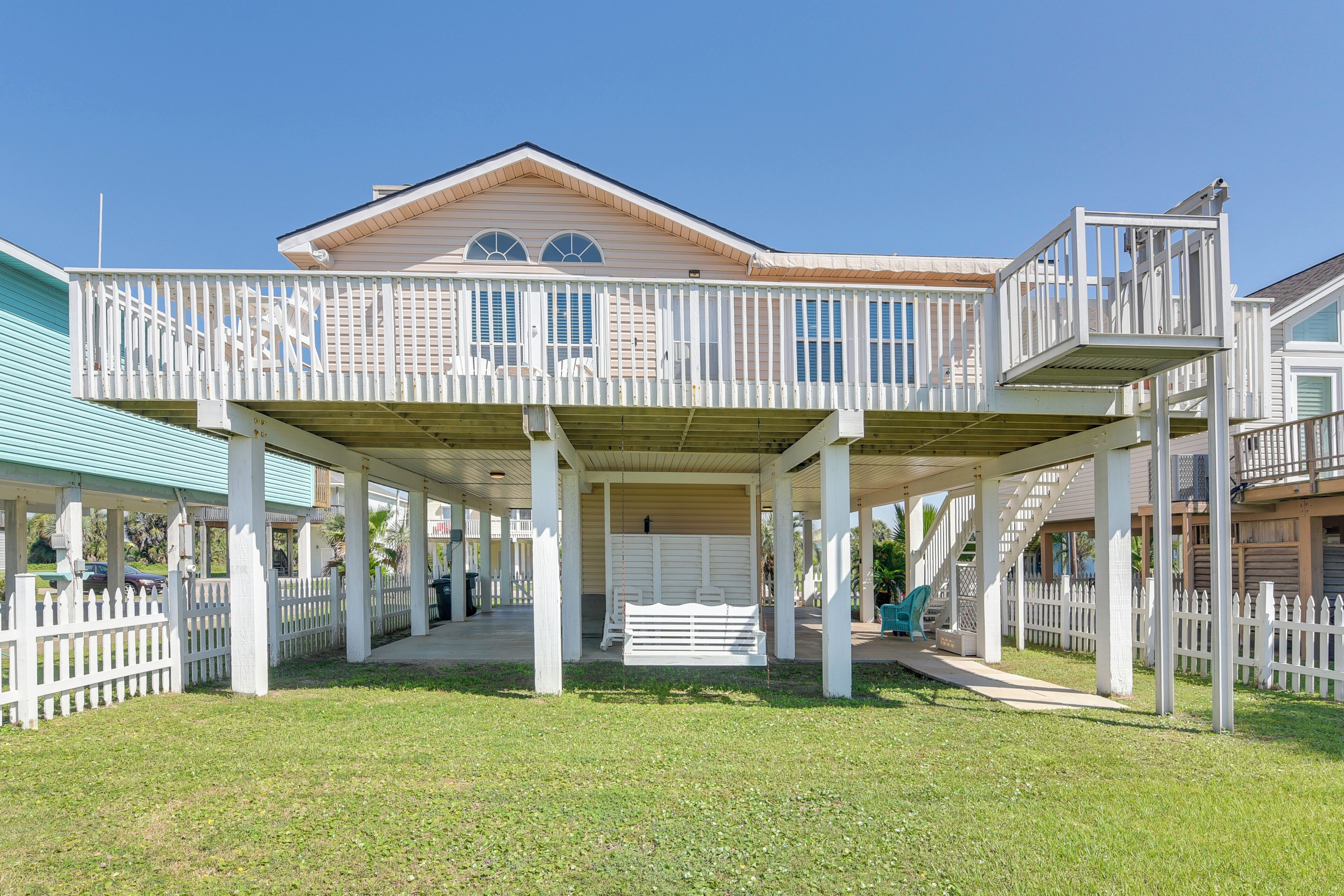A two-story house with a covered porch, white railings, and a small balcony.