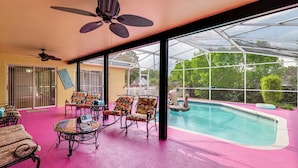 A pool area with chairs and a ceiling fan. - Themed Interior, Poolside Fun! Villa Near Disney (Davenport)
