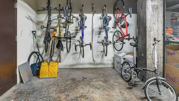 A bike storage area with multiple bicycles and a folding chair.