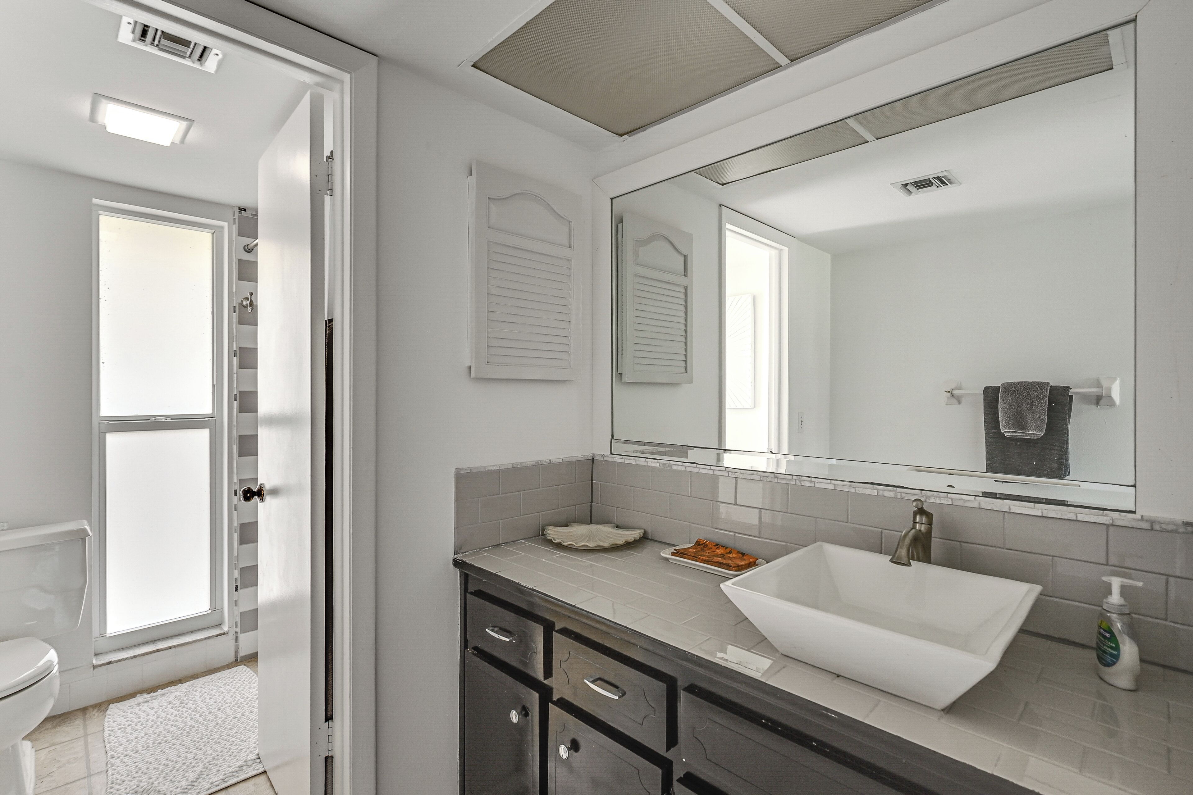 A bathroom with a white sink, a mirror, and a towel rack.