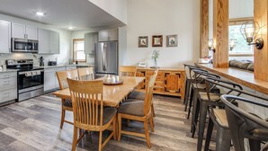 A modern kitchen with a dining area, stainless steel appliances, and wooden furniture. - Ski-in/ski-out! Modern Mountainside Stay in Granby (Granby)
