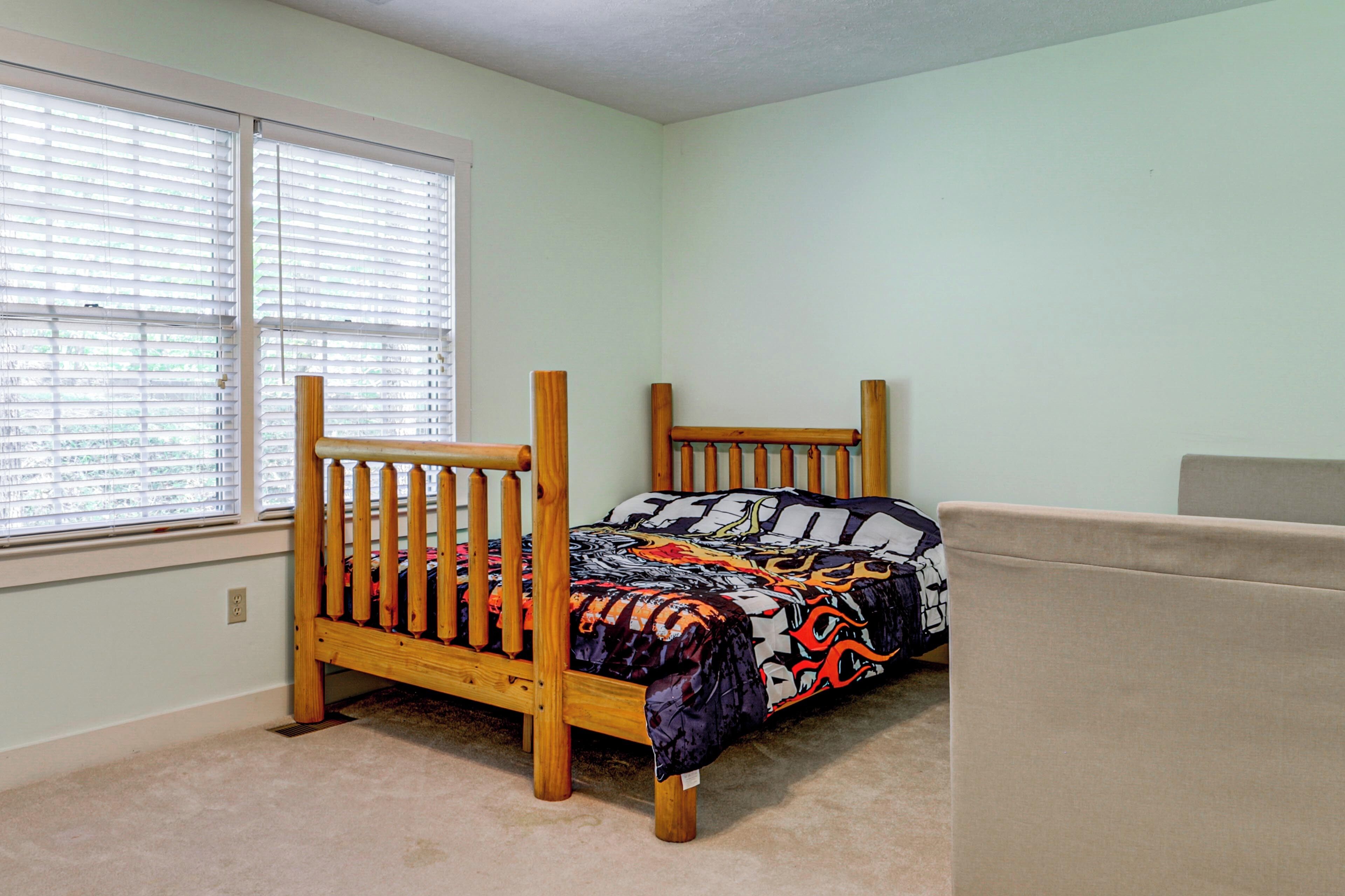 Un dormitorio con una cama individual, una ventana con persianas y una alfombra color beige.