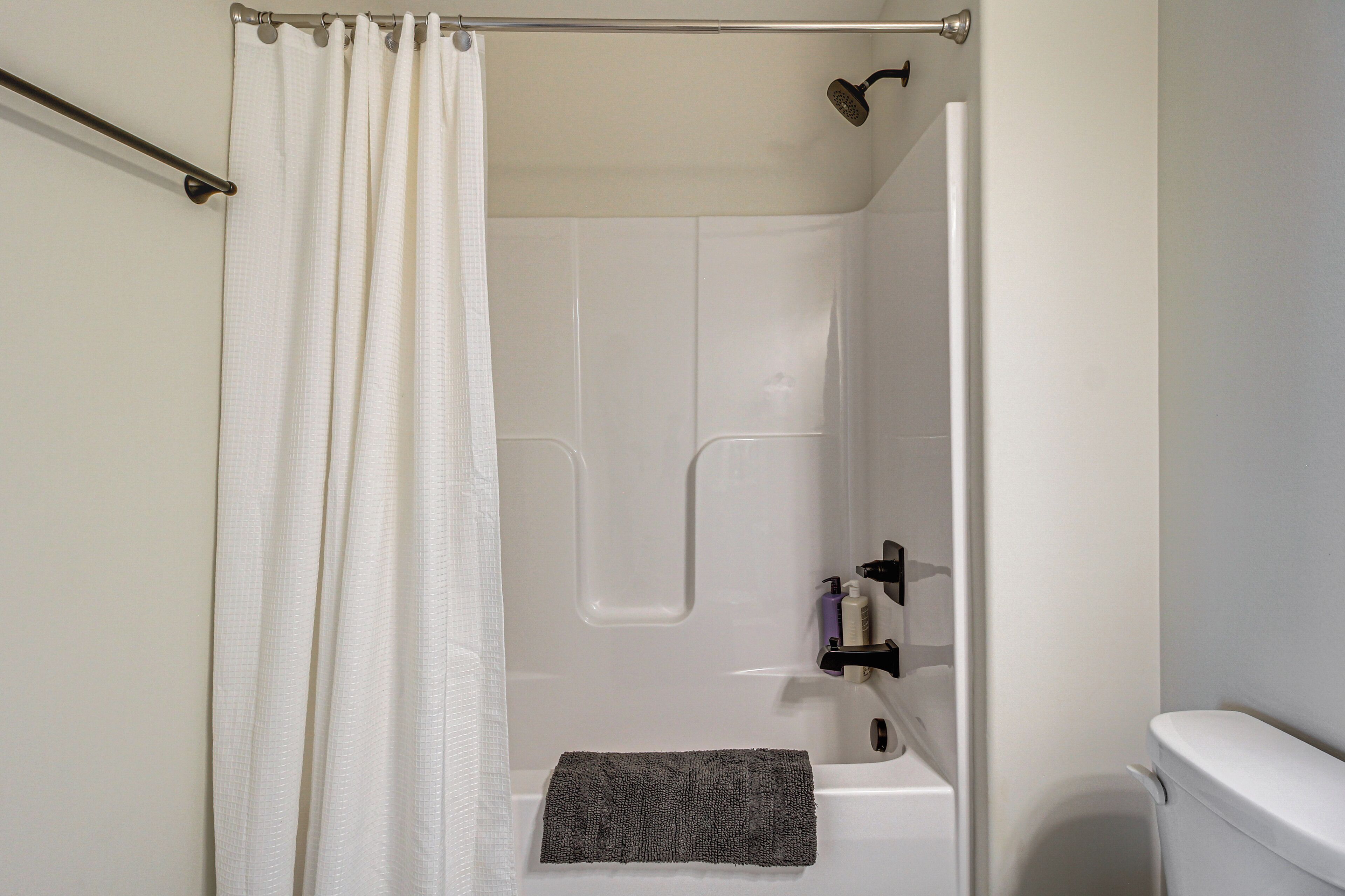 Une salle de bain avec une douche, des toilettes et un porte-serviettes.