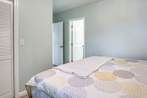 A bedroom with a bed, a door, and a light switch on the wall. - Walk to Sand! Ewa Beach Group Retreat (Ewa Beach)