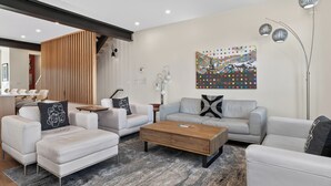 A modern living room with a sofa, armchairs, a coffee table, and a decorative painting. - On Fraser River w/ Trail Access! Mtn-view Unit (Fraser)