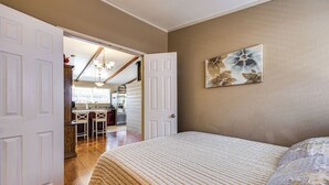 A bedroom with a bed, a door leading to a kitchen, and a dining area. - Wfh-friendly Retreat w/ Office Near Silicon Valley (Hayward)