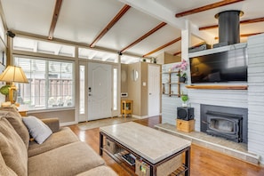 A living room with a fireplace, wooden beams, a sofa, and a coffee table.