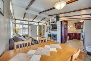 A spacious kitchen with a large wooden table, a built-in stove, and dark wooden cabinets.