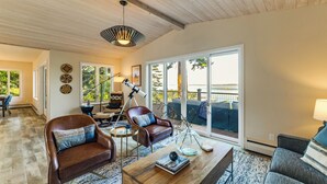 A spacious living room with a wooden ceiling, leather sofas, a coffee table, and a telescope. - Snow Goose Point: Stunning Views & New Hot Tub! (Anacortes)