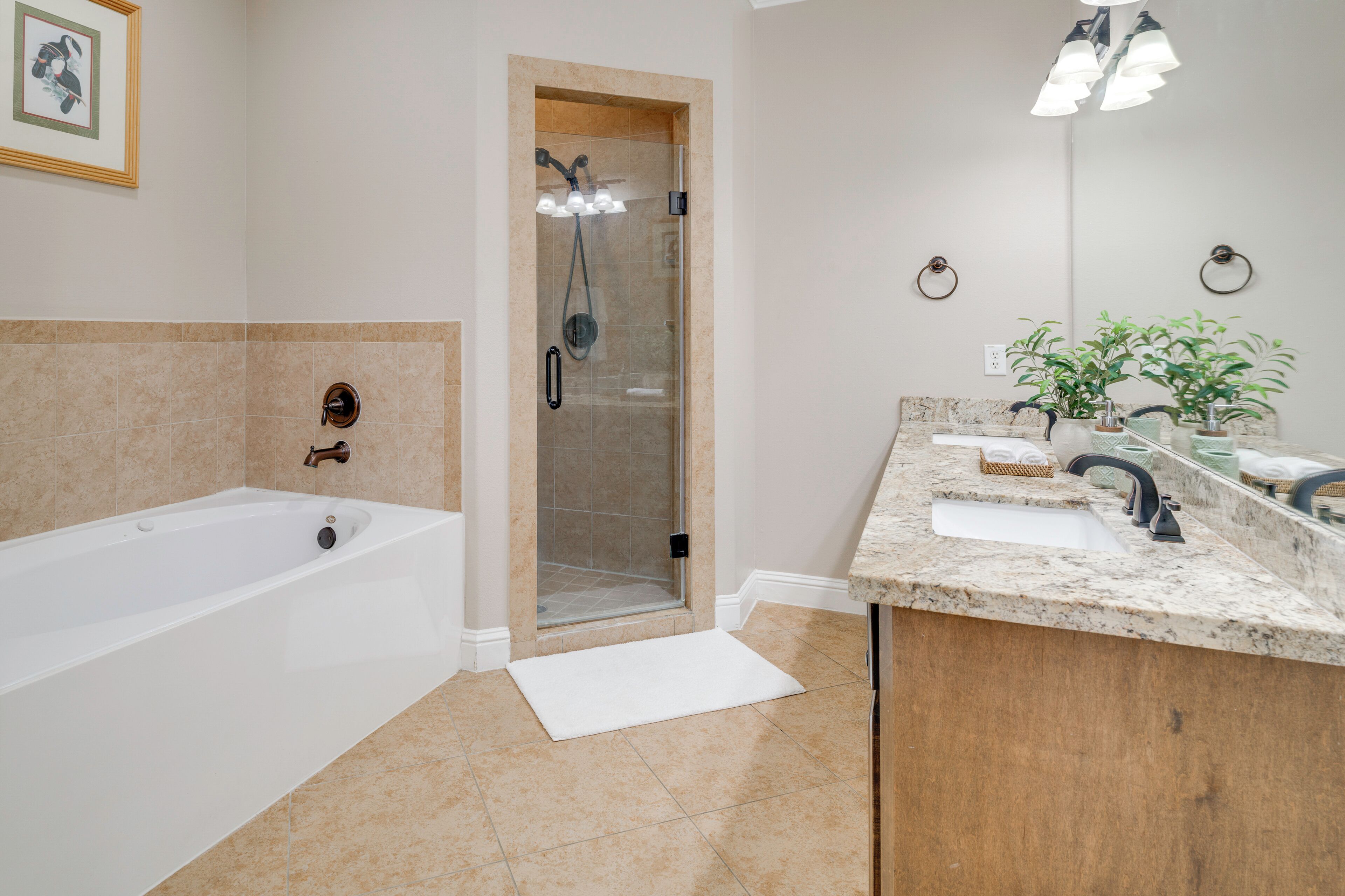 A modern bathroom with a bathtub, shower, sink, and countertop.