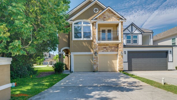 A two-story house with a garage, a balcony, and a well-maintained lawn. - Boating, Fishing & Poolside Fun! Montgomery Escape (Montgomery)