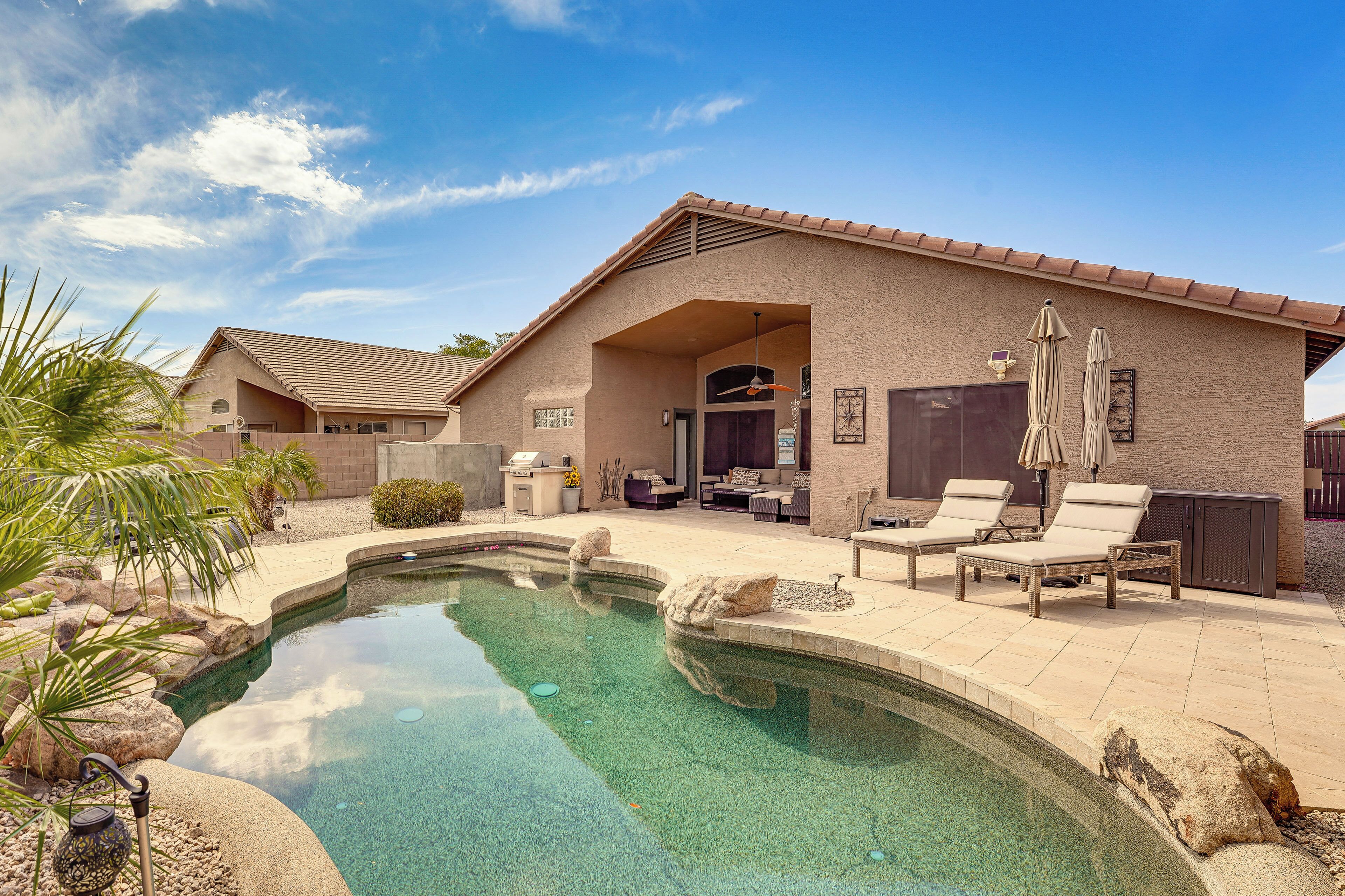A house with a swimming pool, outdoor seating, and a patio area.