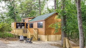 A wooden cabin with a deck, a covered porch, and a gravel ground. - Tiny Cabin on Lake Murray, Private Dock for Boats (Chapin)