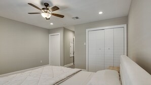 A bedroom with a bed, a ceiling fan, and a closet. - Gateway to New Orleans! Modern Condo w/ Pool (Kenner)