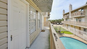 A hotel with a pool, balconies, and a covered outdoor area. - Gateway to New Orleans! Modern Condo w/ Pool (Kenner)