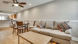 A modern living room with a sofa, chairs, a coffee table, and a ceiling fan. - Gateway to New Orleans! Modern Condo w/ Pool (Kenner)