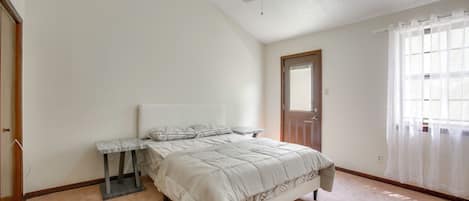 Un dormitorio con cama, mesita de noche y ventilador de techo.