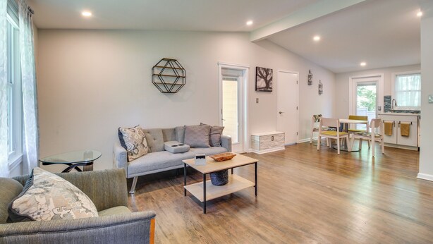 Ein modernes Wohnzimmer mit Sofa, Couchtisch und Essbereich mit Stühlen.