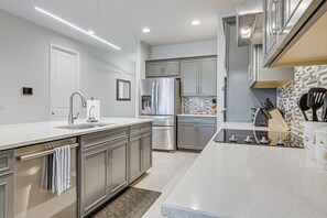 Uma cozinha moderna com eletrodomésticos de aço inoxidável, uma ilha grande e painel de azulejos.