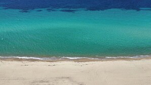 A beach with clear turquoise water and a sandy shore. - Spacious Beachfront Retreat With Large Garden in Ormos Panagias (Sithonia)